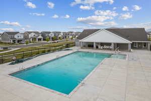 Community pool featuring a patio, fence, and a residential view