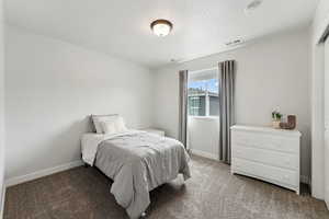 Bedroom with baseboards, light carpet, a textured ceiling, and visible vents