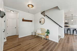 Entryway with stairs, baseboards, visible vents, and wood finished floors