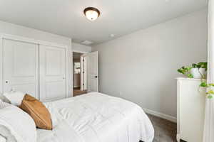 Carpeted bedroom featuring baseboards, visible vents, and a closet