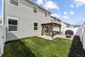 Rear view of house with a patio area, a fenced backyard, a yard, a pergola, and a fire pit