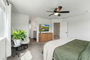 Primary bedroom featuring connected bathroom, carpet, a ceiling fan, baseboards, and visible vents