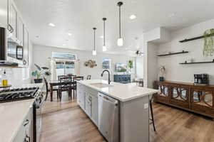 Kitchen featuring appliances with stainless steel finishes, a sink, a textured ceiling, light wood-style flooring, and recessed lighting