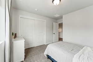 Carpeted bedroom featuring a closet