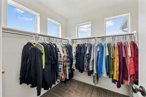 Primary walk in closet featuring carpet flooring