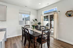 Dining area featuring visible vents, baseboards, and dark wood-style floors