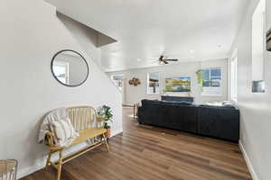 Living area featuring ceiling fan, a textured ceiling, recessed lighting, baseboards, and wood finished floors