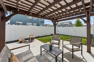 View of patio / terrace featuring a pergola, a gate, a fenced backyard, and an outdoor living space with a fire pit