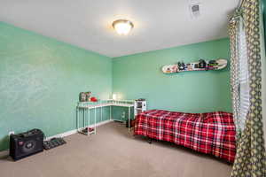 Carpeted bedroom featuring a textured ceiling, visible vents, and baseboards