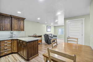 Kitchen with backsplash, a peninsula, recessed lighting, and light wood-type flooring