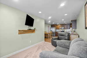 Living room featuring recessed lighting, baseboards, and light colored carpet
