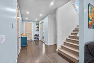 Foyer entrance featuring dark wood-style flooring, french doors, recessed lighting, baseboards, and stairway