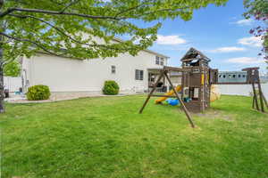 View of yard featuring a playground and fence