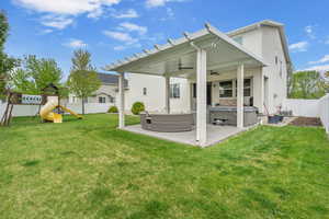 Back of property featuring a hot tub, stucco siding, a fenced backyard, a patio area, and a ceiling fan