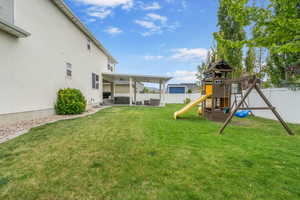 View of yard with a patio, a jacuzzi, a fenced backyard, and a playground