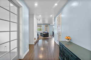 Hallway with recessed lighting, a textured ceiling, dark wood finished floors, and baseboards
