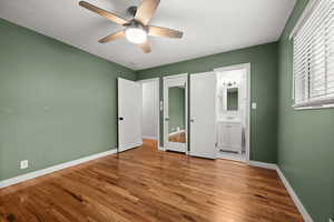 Unfurnished bedroom featuring baseboards, light wood-type flooring, connected bathroom, and ceiling fan