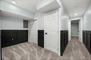 Hall with carpet floors, electric panel, and recessed lighting
