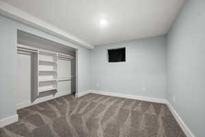 Unfurnished bedroom featuring carpet, baseboards, and a closet