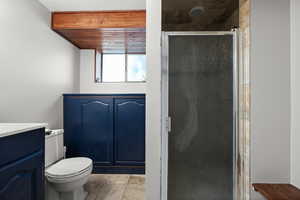 Full bathroom with a shower stall, vanity, and toilet