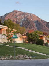 View of front of house featuring a front lawn, a mountain view, and a chimney