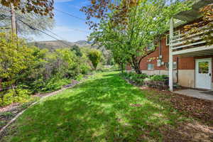 View of yard with a mountain view and a balcony