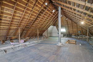 Unfinished attic with an upstairs landing