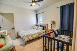 Bedroom featuring ceiling fan and carpet