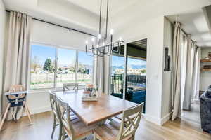 Dining space featuring light wood-type flooring, baseboards, and an inviting chandelier
