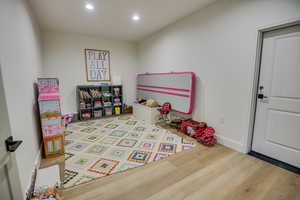 Game room with recessed lighting, baseboards, and wood finished floors