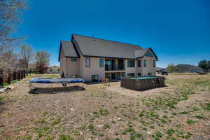 Rear view of property with roof with shingles, a fenced in pool, a trampoline, and a balcony