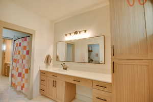 Full bath with vanity, marble finish floor, and curtained shower