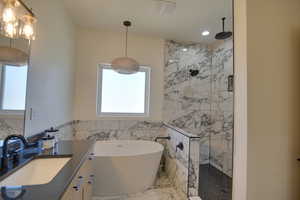 Bathroom with walk in shower, tile walls, and a healthy amount of sunlight