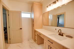 Ensuite bathroom featuring vanity, ensuite bathroom, and marble finish floor