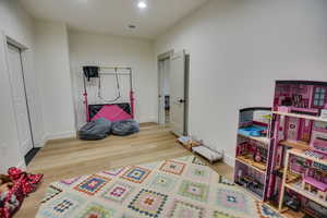 Rec room with recessed lighting, baseboards, visible vents, and wood finished floors