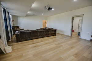 Living area featuring recessed lighting, baseboards, light wood-type flooring, and visible vents