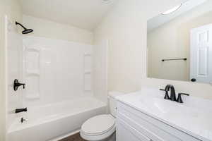 Bathroom featuring vanity, shower / bathing tub combination, and toilet