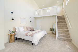 Carpeted bedroom with recessed lighting, a high ceiling, visible vents, and baseboards