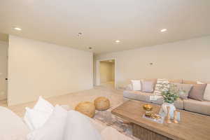 Living room with recessed lighting, baseboards, and light colored carpet