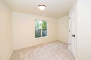 Carpeted empty room with visible vents and baseboards