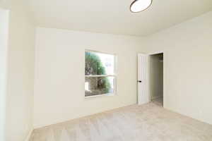 Unfurnished bedroom with carpet floors and baseboards