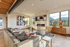 Living room featuring visible vents, baseboards, light wood-style floors, and a fireplace