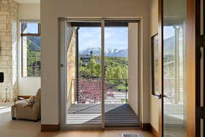 Doorway with a mountain view, plenty of natural light, and baseboards