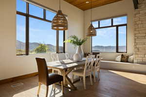 Dining space with a mountain view, hardwood / wood-style flooring, baseboards, and wooden ceiling