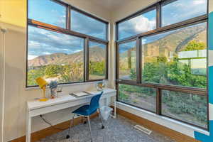 Office with baseboards, visible vents, built in desk, and a mountain view