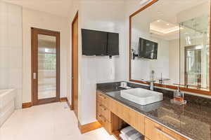 Bathroom featuring vanity, tile patterned flooring, recessed lighting, a raised ceiling, and baseboards