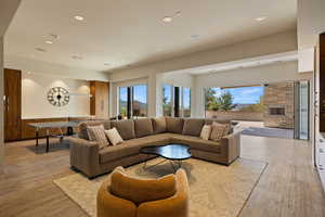 Living room with light wood finished floors, a fireplace, and recessed lighting