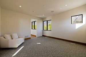 Living area featuring baseboards, recessed lighting, and carpet floors