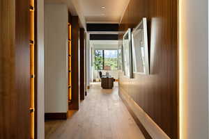 Corridor with light wood-type flooring and baseboards