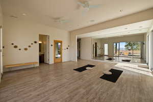 Exercise area featuring light wood-type flooring, ceiling fan, baseboards, and recessed lighting